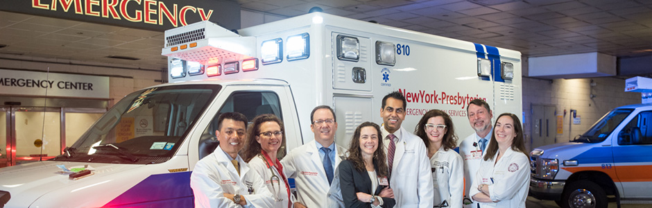 Group photo of Emergency Medicine physicians in front of an ambulance.