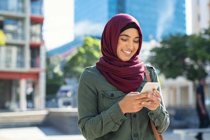 Woman in head scarf looking at phone